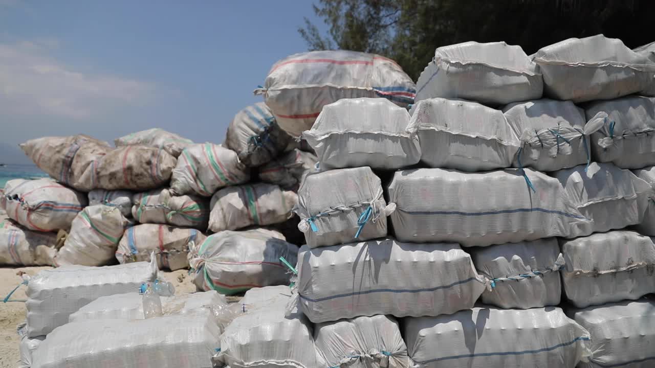 People Hauling Scrap Materials For Recycling At The Coast In Gili Trawangan Island, Indonesia - pan left, tracking shot