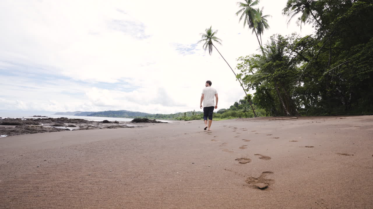 turista masculino caucásico que camina solo en una playa tropical de arena blanca paradisíaca en costa rica américa central viaje destino de vacaciones