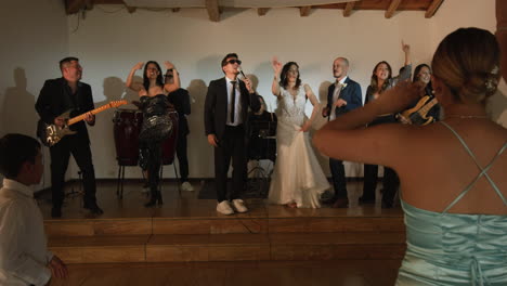 clip of a wedding where the newlyweds dance happily with their guests and bridesmaids.