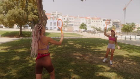 Women playing tennis in a park