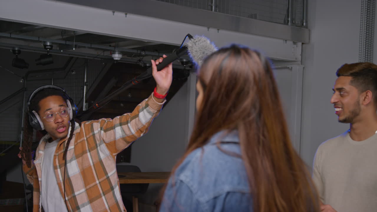 grabador de sonido masculino con actores que trabajan en el set de filmación de películas o videos en el estudio 3