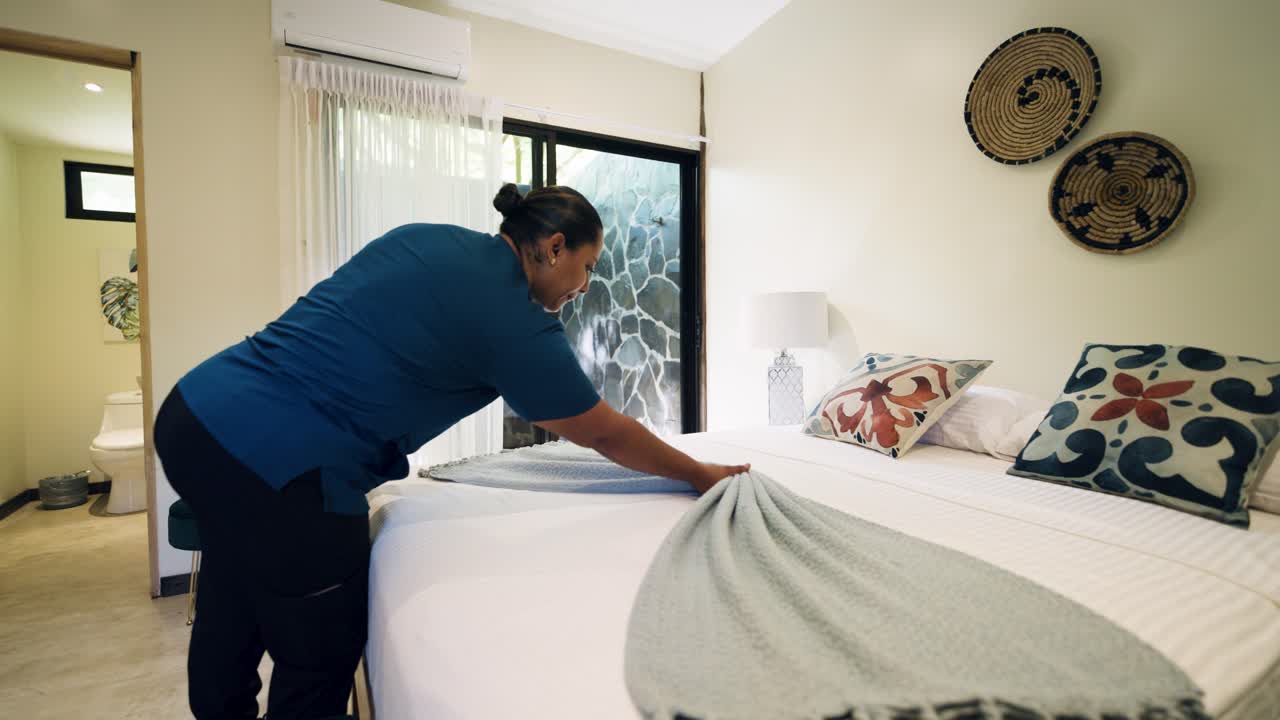 Empregada de hotel arrumando o quarto