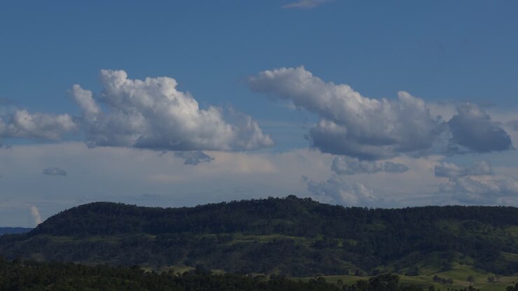 Clouds moving swiftly over a hilly landscape
