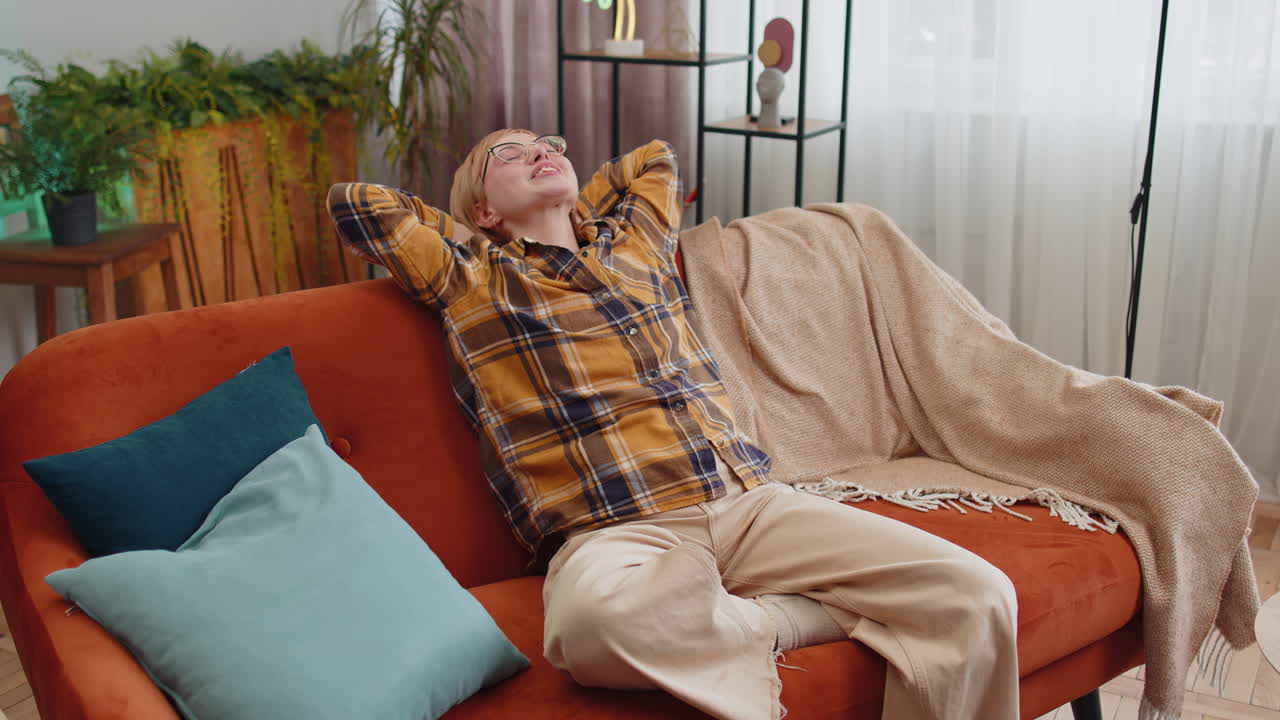 Tired lazy woman enjoy relaxing on home sofa resting napping after hard working day closed her eyes