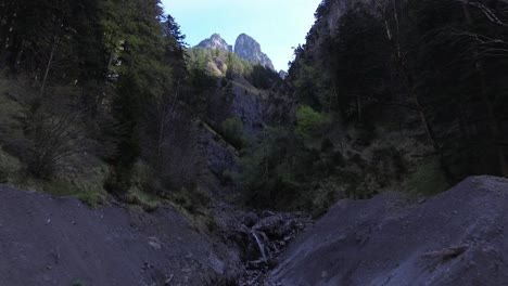 Drone-Fly-along-Mountain-Stream-surrounded-by-Forest-in-Austria,-Europe