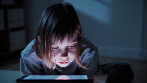 niño que usa la tableta por la noche