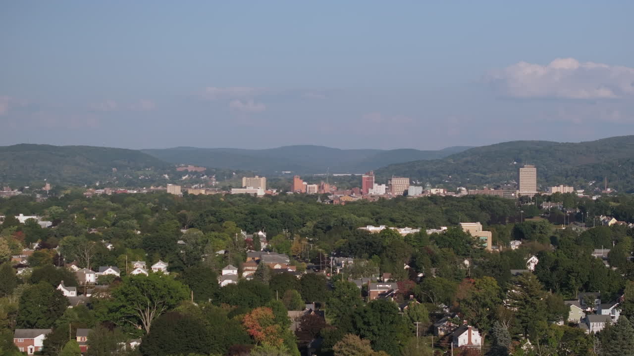 Aerial View of a City Skyline Surrounded by Green Hills