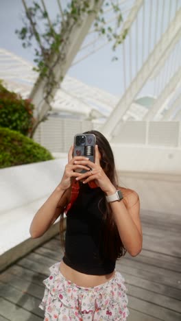 mujer tomando fotos en un parque moderno