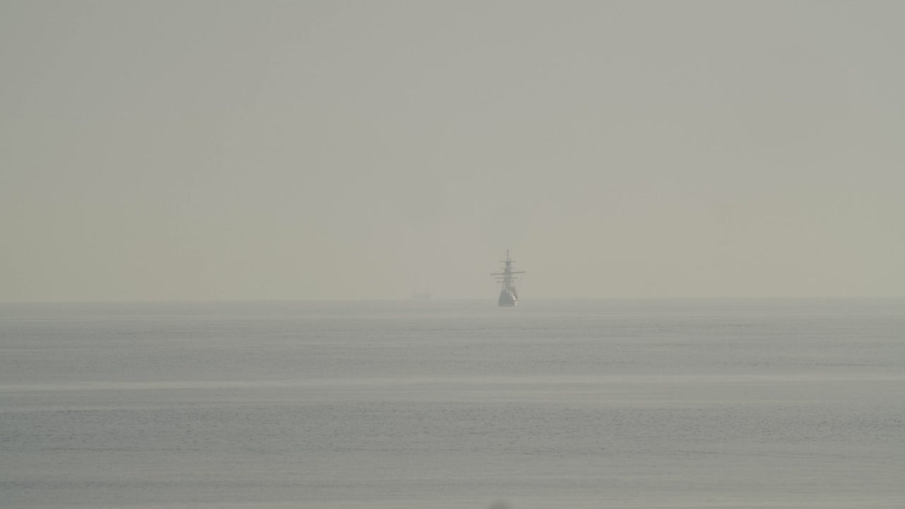 페르디난드 마젤란 나오 빅토리아 카락 보트 복제품은 슬로우 모션 60fps로 잔잔한 바다에서 일출 시 지중해의 멀리 항해합니다.