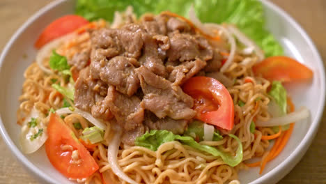 instant noodle spicy salad with pork on white plate - asian food style