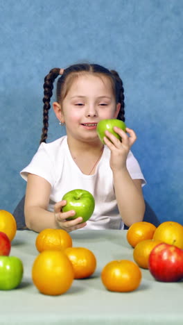 beautiful girl with apple. little girl holds in hand ripe apples on background