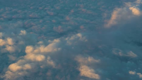 video shot downwards flying over different layers of clouds during sunrise