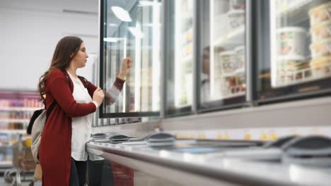 woman shopping for frozen foods in a grocery store