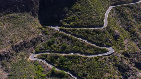 scenic winding mountain road going up steep slope in teno massif, aerial