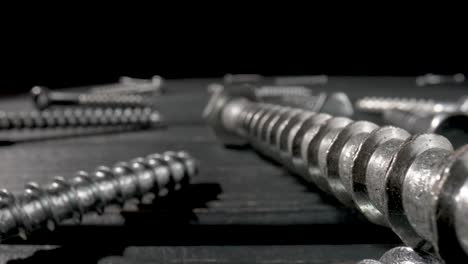 close-up of metal screws and bolts on a dark surface