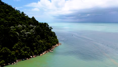 Dron-Aéreo-Copia-De-Seguridad-Del-Mar-Azul-Y-El-Denso-Bosque-De-árboles-A-Lo-Largo-De-La-Isla-En-El-Parque-Nacional-De-Penang,-Penang,-Malasia-Durante-El-Día