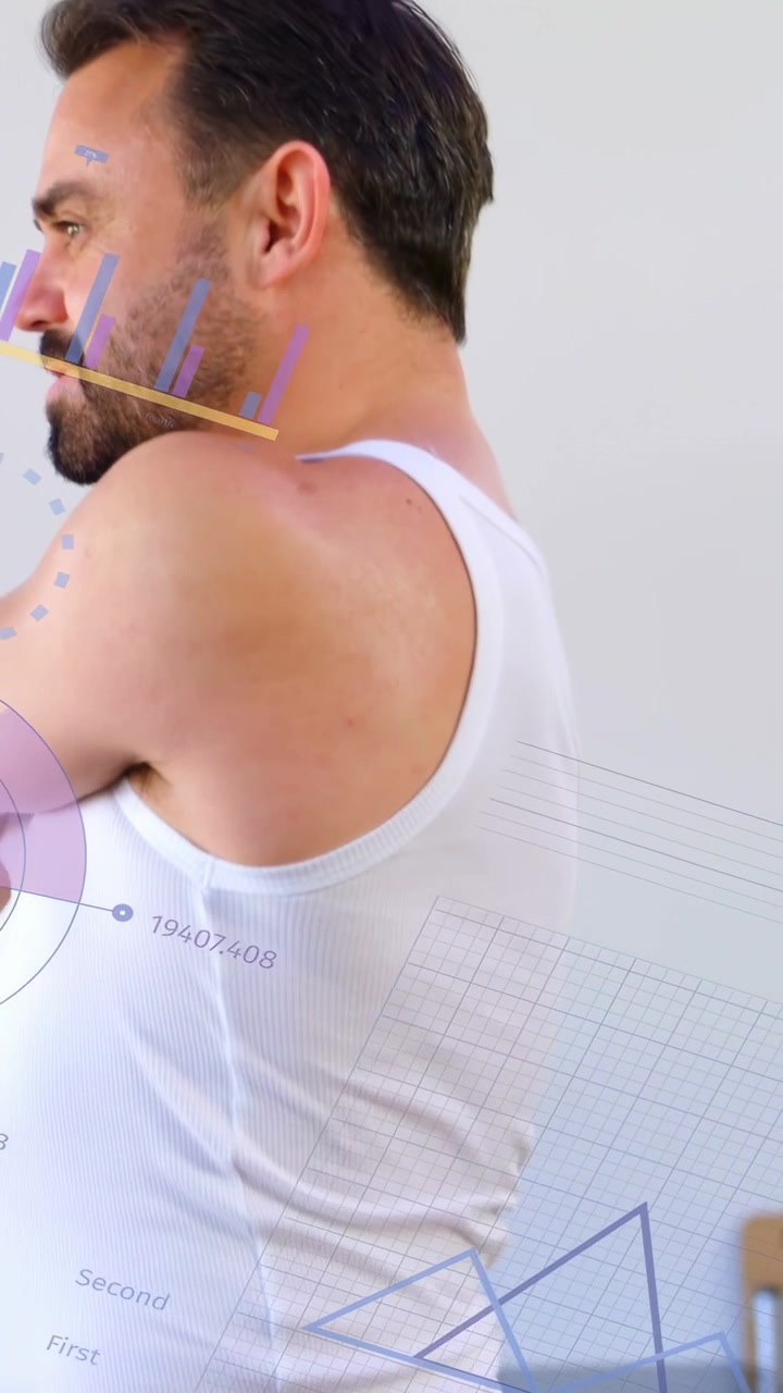 Vertical video: Man arms folded rotating torso turning as cam rising showing tech charts on torso