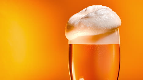 Lager-beer-settles-in-the-glass-with-a-white-cap-of-foam