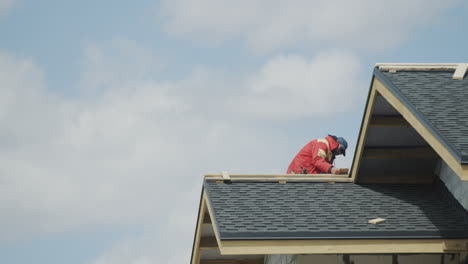 the builder is working on the roof of the house - laying shingles