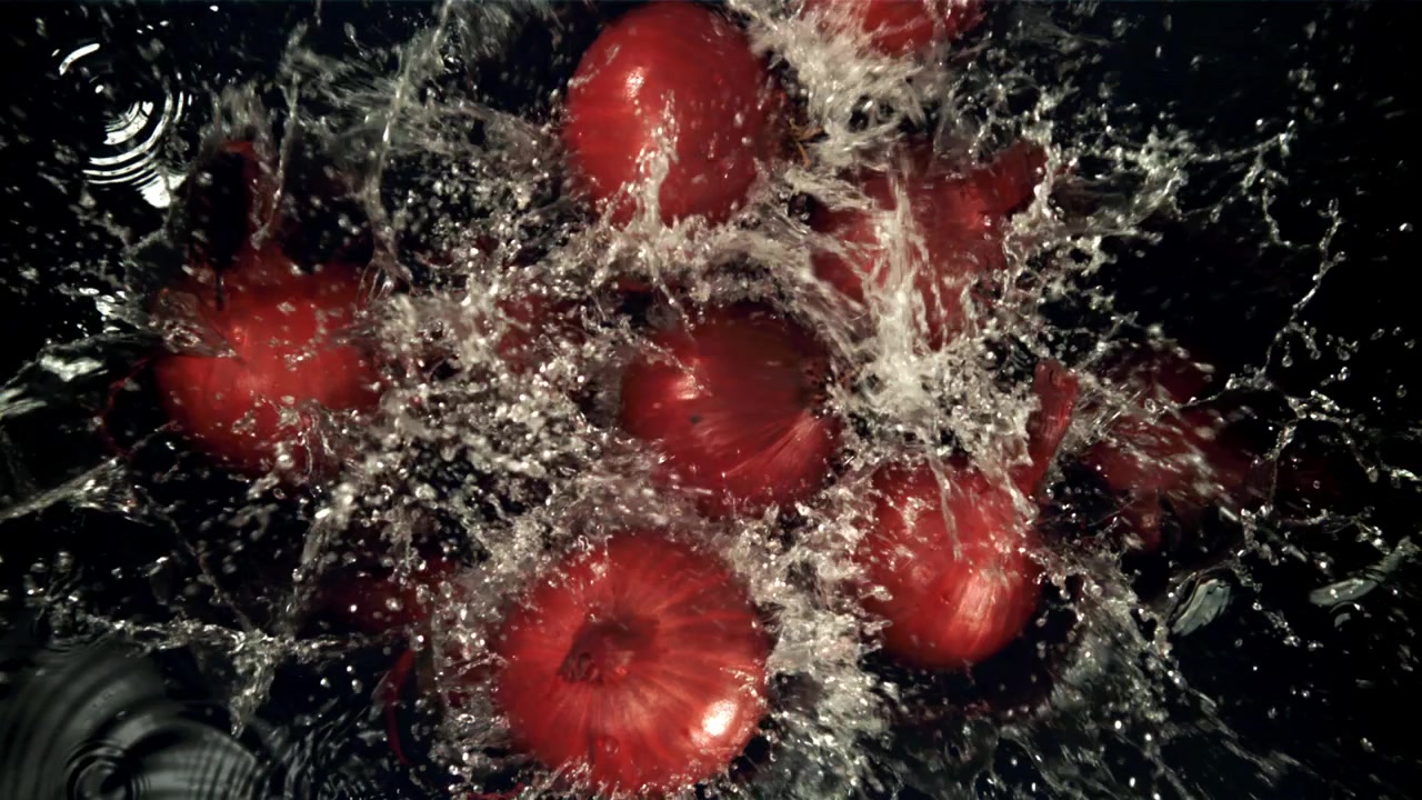 Cipolle rosse fresche con schizzi d'acqua al rallentatore