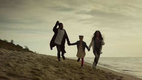 Playing-family-running-coast-at-evening-sea-beach.-People-having-fun-on-nature.
