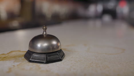 Close-up-of-a-woman's-hand-ringing-a-call-bell-at-an-old-diner