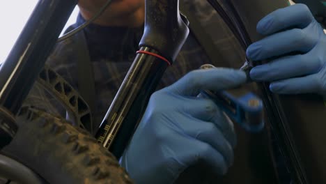 Man-repairing-bicycle-in-workshop-4k