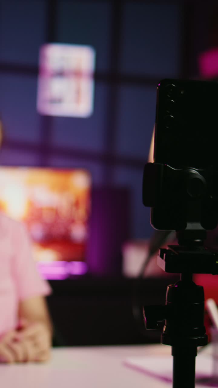 Vertical video Focus on phone camera capturing footage of kid in blurry background discussing topics