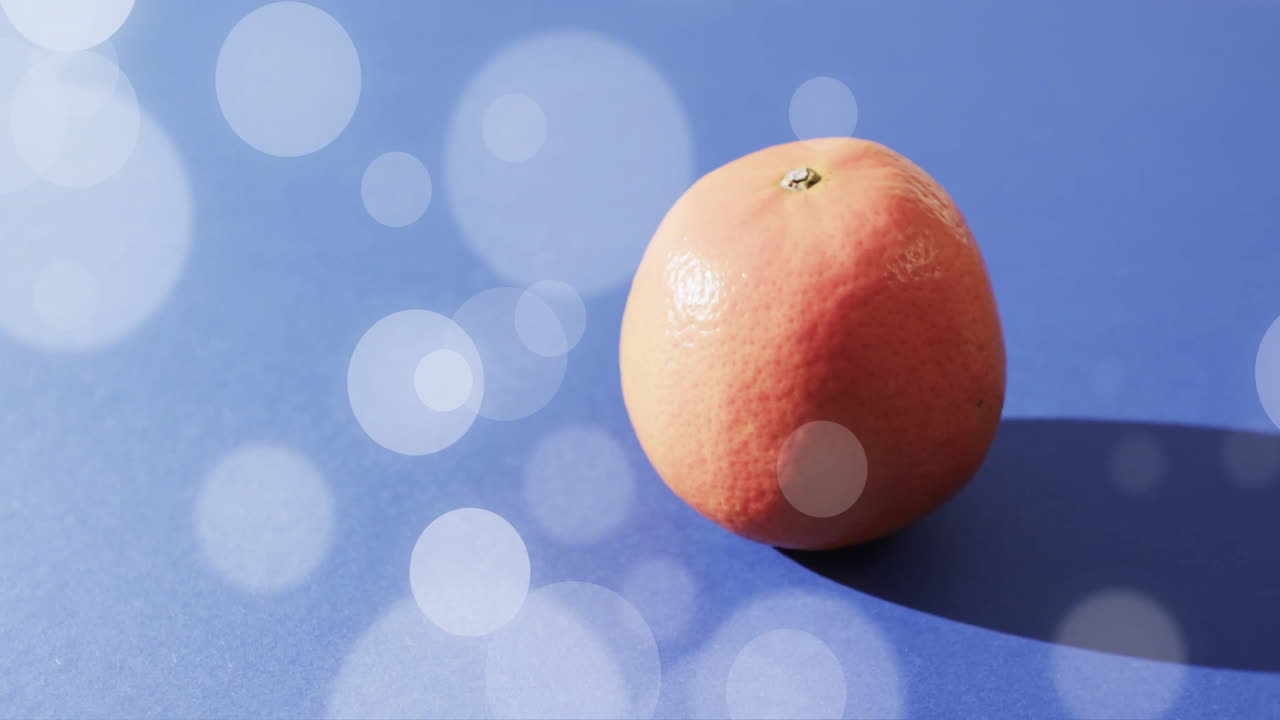 composición de naranja y manchas de luz sobre fondo azul