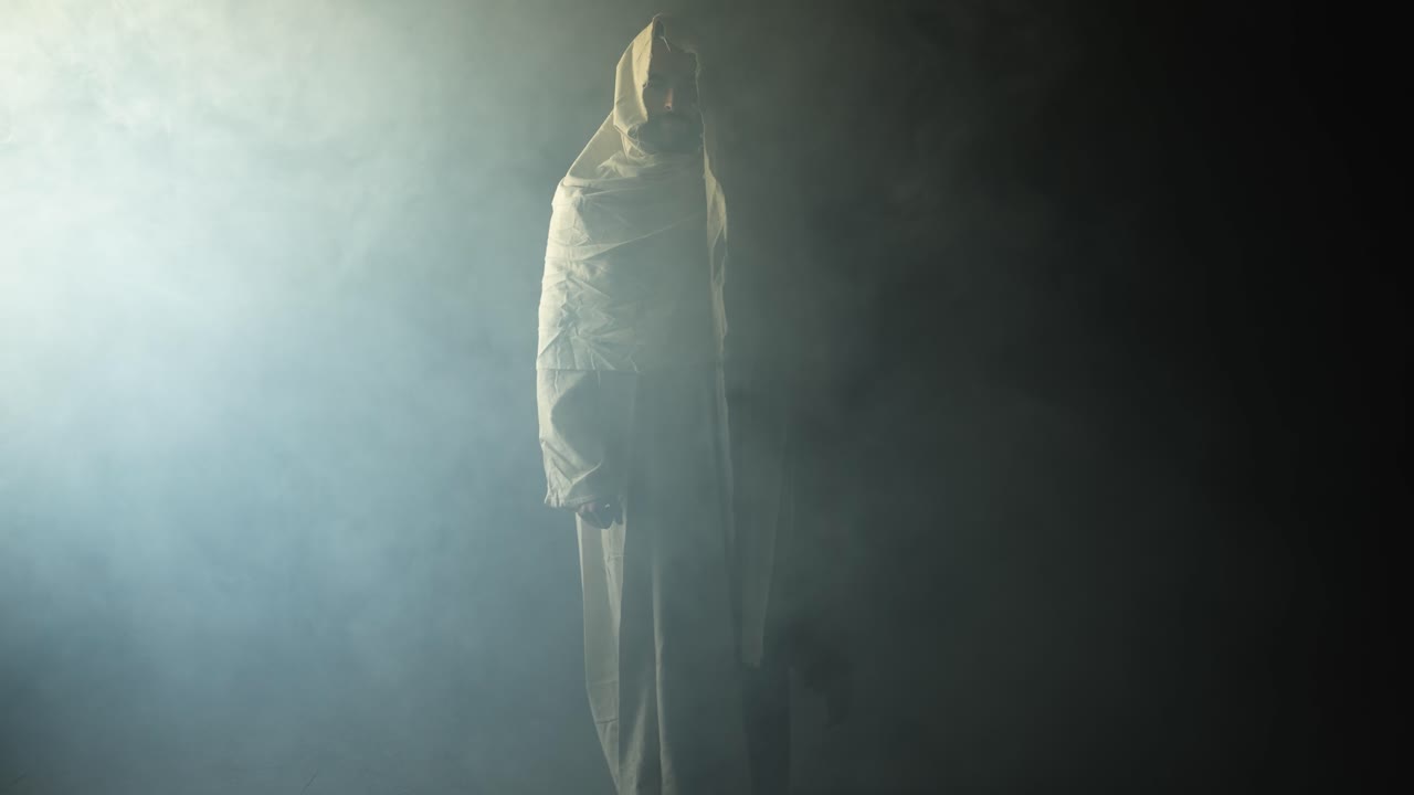 Jesus Christ shrouded in ambient bright light, symbolizing the resurrected Jesus Christ inside the tomb in bright, dramatic, glowing, holy light as representation of the Easter Sunday resurrection.
