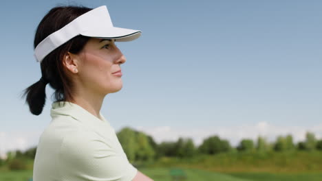 Golf-female-player-with-cap-on-golf-course.