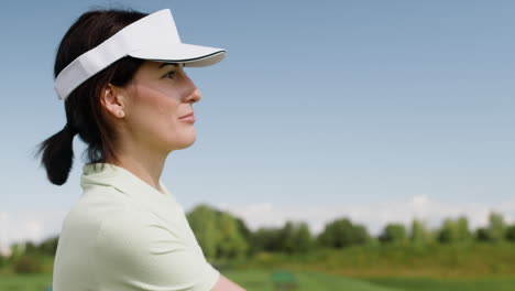 golf female player with cap on golf course.