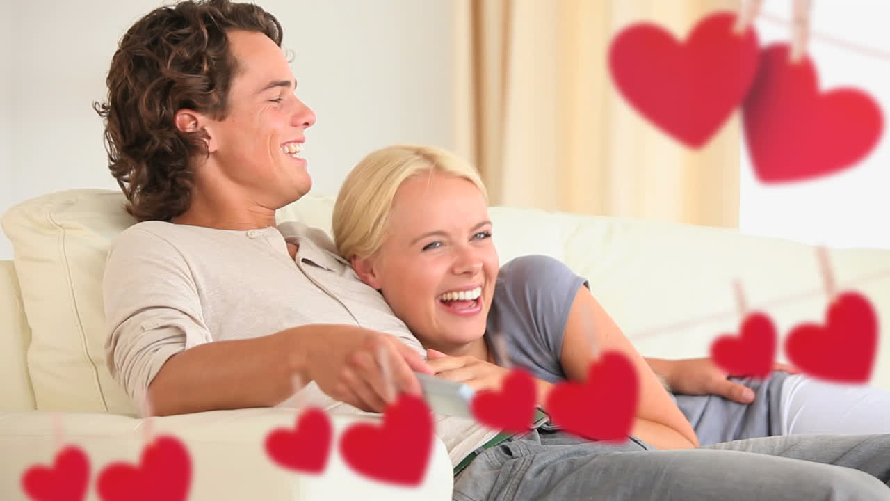 Jovem casal feliz assistindo tv