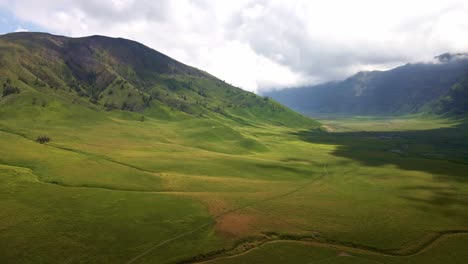 captivating-transition-from-sun-drenched-hillsides-to-the-mystical-embrace-of-cloudy-shadows,-4k-aerial-drone-footage