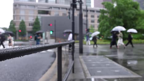 walking people on the street in marunouchi tokyo rainy day