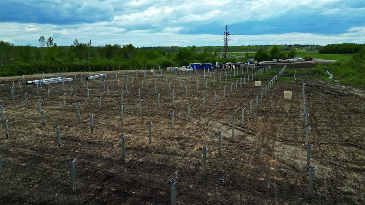 Drone fly over metal beams, aerial view of solar farm under construction showing renewable energy