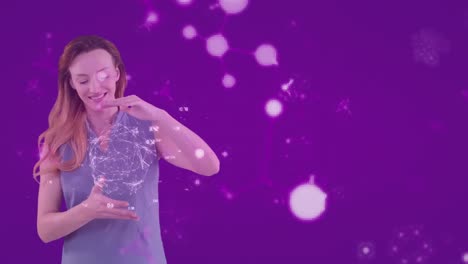 animación de una mujer caucásica que presenta un modelo de globo con moléculas flotando sobre un fondo púrpura