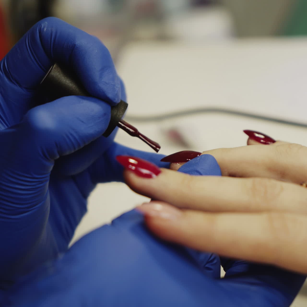 Master of manicure paints nails to the girl in the salon. Hand care in the spa. Square video