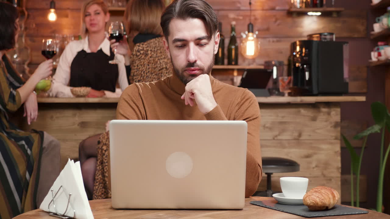 hombre trabajando en una computadora portátil en un café