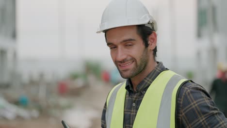 civil engineer or contractor or foreman work in housing construction site, use smartphone talking with team or partner about work. after hanging up phone he looking at the camera smile and arm crossed.