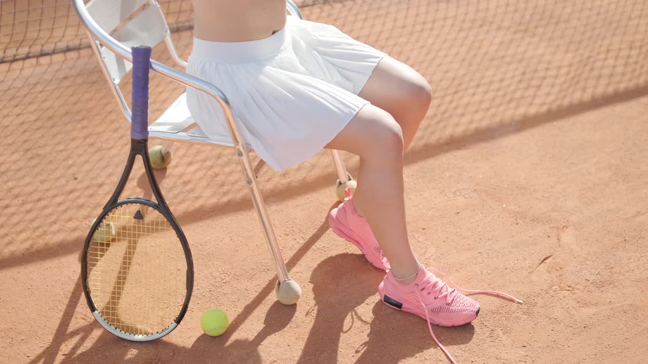 코치와 함께 야외 코트에서 테니스를 연습하는 젊은 여성. 코치는 선수가 그녀의 기술에 대해 일하면서, 운동 훈련 세션에서 그녀의 스트로크를 완성하는 동안 지침을 제공합니다.