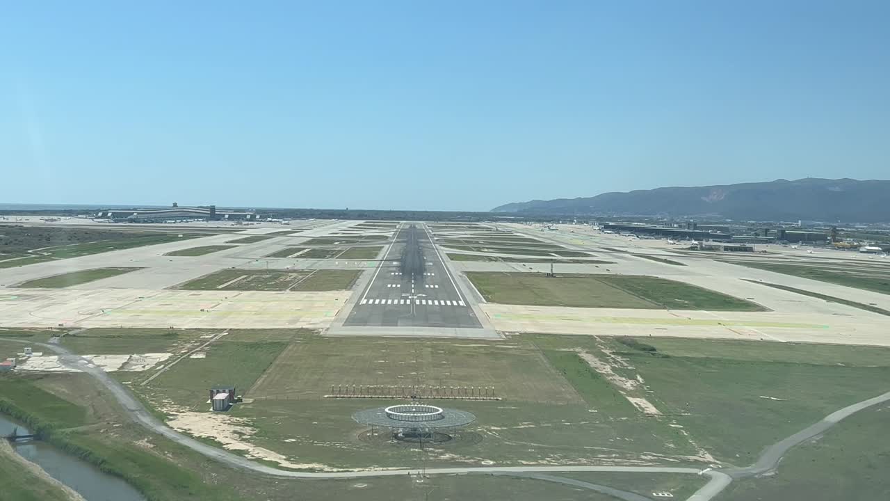 aterrizaje en tiempo real en el aeropuerto de barcelona disparado desde la cabina de un avión en una brillante mañana soleada de primavera