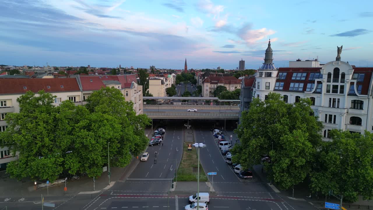 Aerial view of a European city street with an overpass and historic buildings at dusk