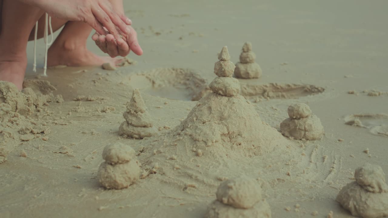 Construindo castelos de areia na areia molhada da praia, desfrutando de divertidas atividades de lazer infantis no resort, criando pequenas estruturas arquitetônicas durante o lazer de verão na praia