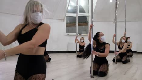 women practicing pole fitness and dance in a studio