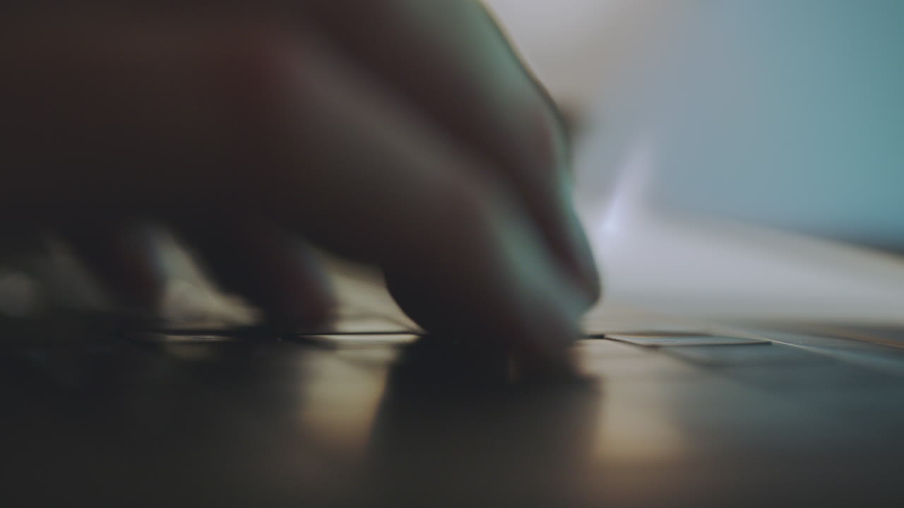 Close-up of hands typing on a laptop keyboard