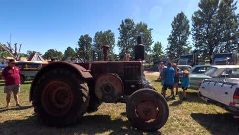 people gathered around a vintage tractor outdoors