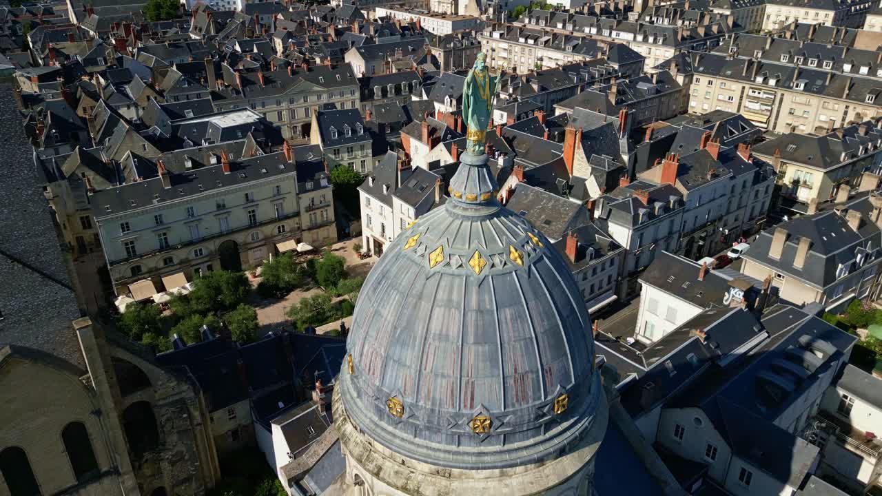Aerial orbit of saint on top of Basilique St. Martin and Tours cityscape under clear skies, France, establishing overview