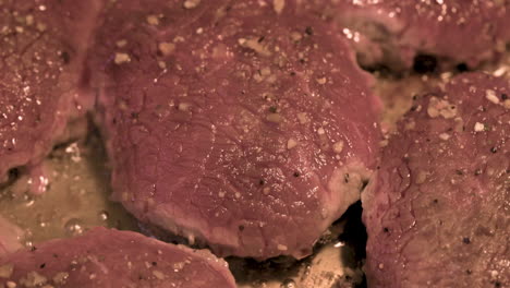 tiro macro de deliciosos bistecs de carne jugosa cocinando en sartén