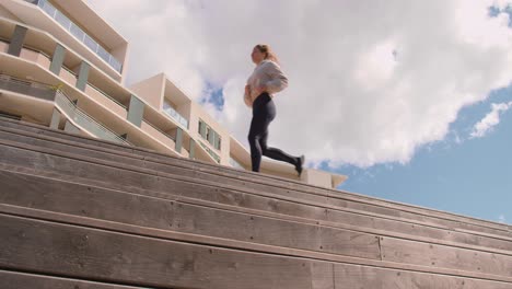 una mujer que realiza un ejercicio de jogging a través de las escaleras de madera